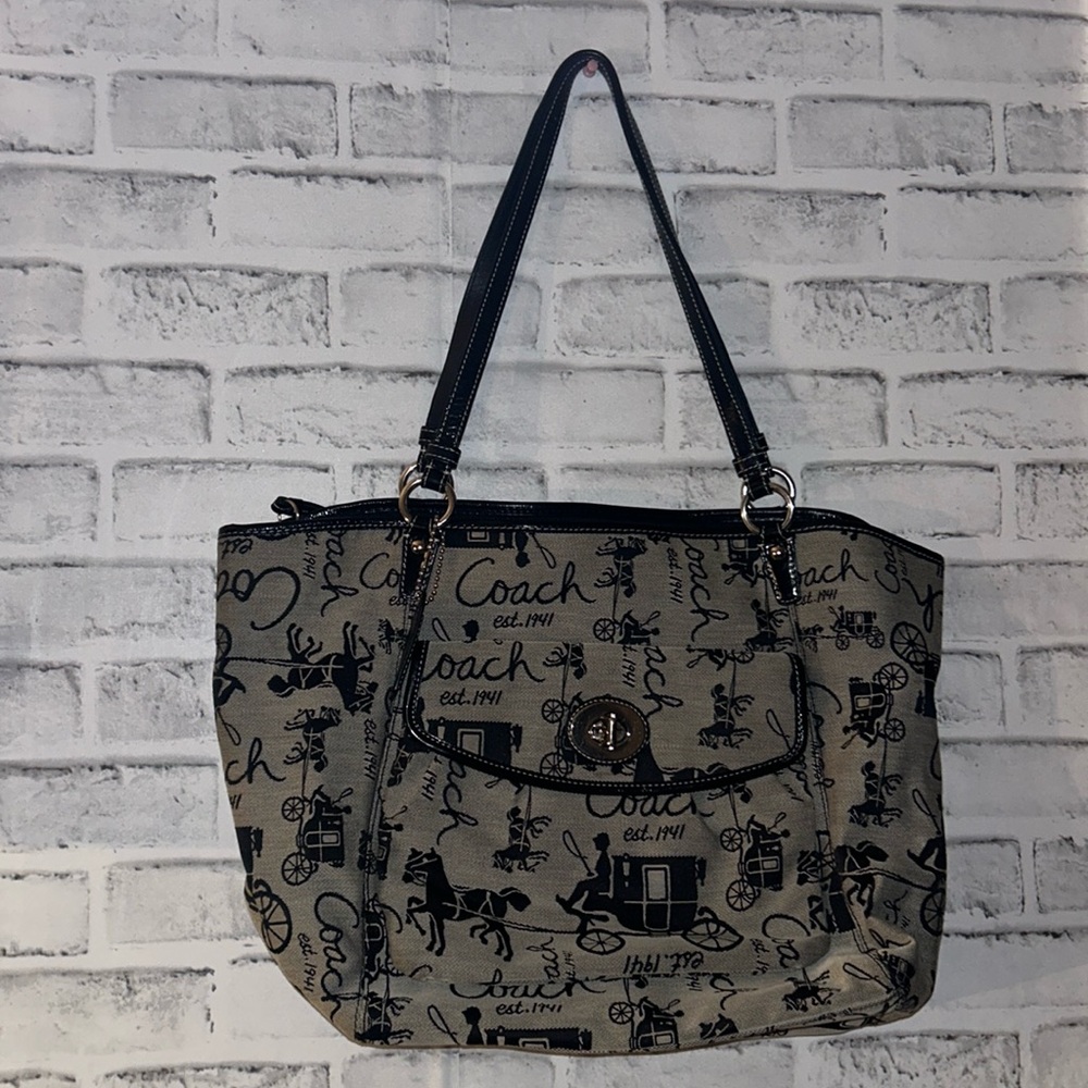 Gray coach bag with black lettering. Inside is a baby blue color.